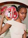 Model holding the ILIA beauty gift set, showcasing its products and design against a mirror.
